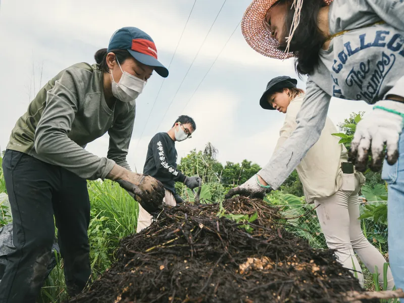 參加者喺農場一齊翻堆肥